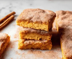 Delicious Pumpkin Snickerdoodle Bars with cinnamon sugar topping on a baking sheet, perfect for fall desserts and holiday treats