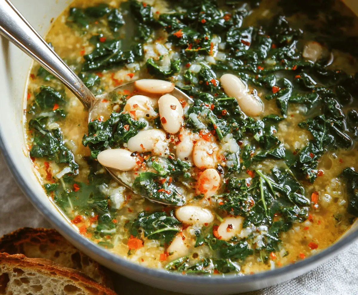 A bowl of hearty white bean and kale soup garnished with fresh herbs, served with crusty bread on the side.