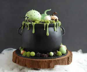 Delicious Witch Cauldron Cake decorated with green frosting, colorful candies, and spooky Halloween accents, perfect for a festive celebration.