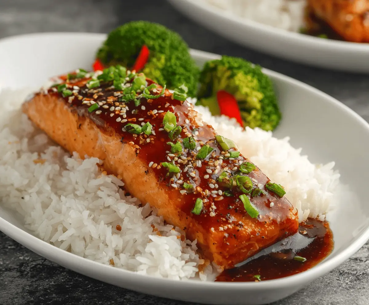 Delicious savory teriyaki salmon fillet with a glossy glaze and fresh garnish.