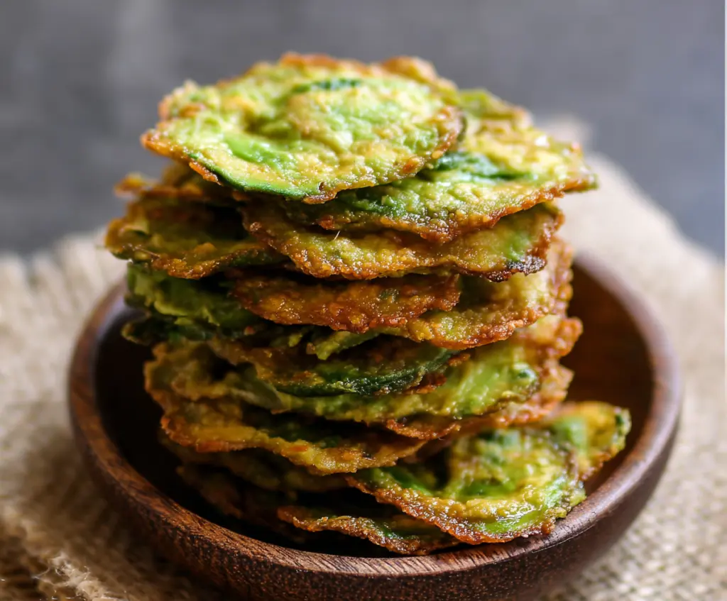 Crispy homemade avocado chips on a white plate, healthy snack option