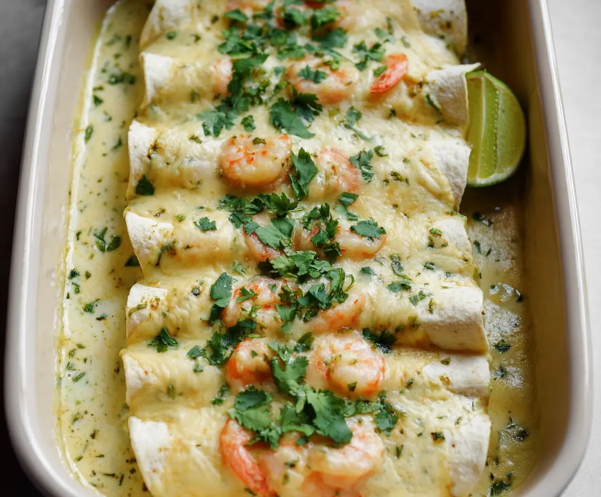 Delicious shrimp enchiladas topped with creamy poblano sauce on a vibrant plate.