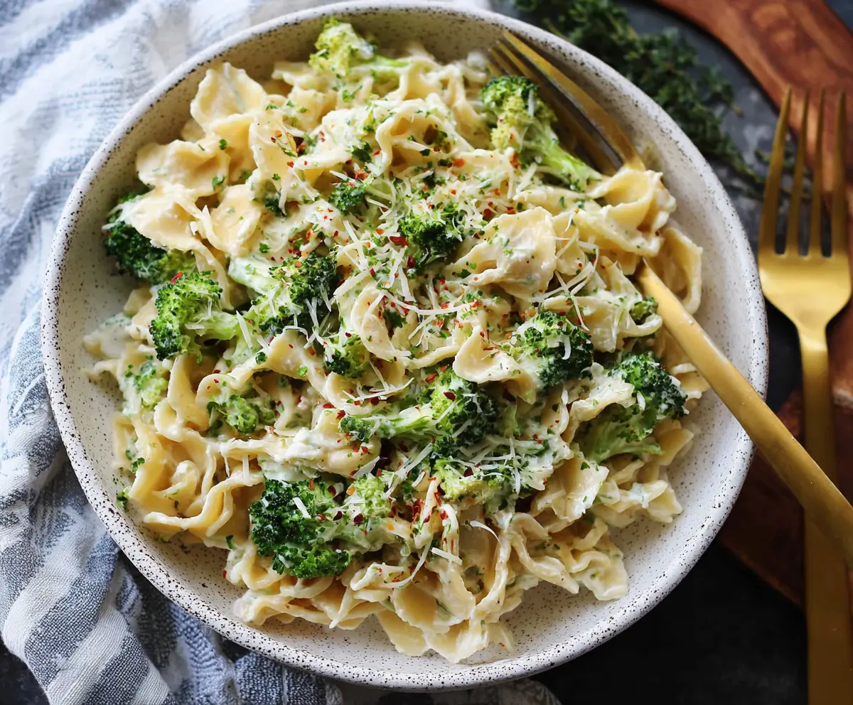 Creamy Boursin cheese pasta with fresh broccoli florets served on a white plate.