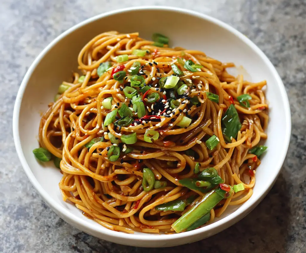 Delicious Cold Spicy Szechuan Sesame Noodles served in a bowl with garnishes